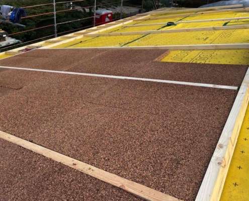 Per la copertura del latero cemento, si procede con la posa di uno strato separatore impermeabile e traspirante KoSep.G, seguito dall'installazione di pannelli in sughero biondo naturale compresso a grana media SoKoVerd.AF con uno spessore complessivo di 24 cm.