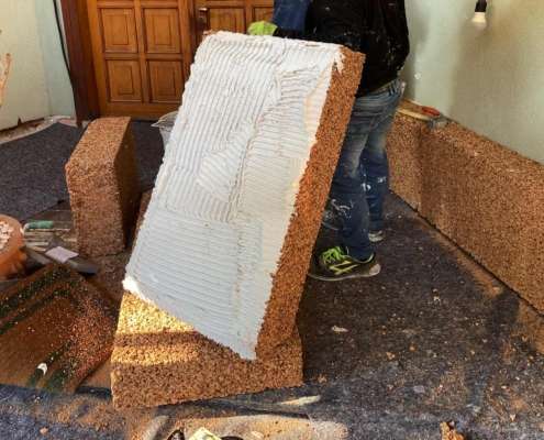 a person holding a white foamy piece of wood